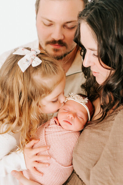 Springfield MO maternity photographer captures pregnant mom kneeling in field holding belly