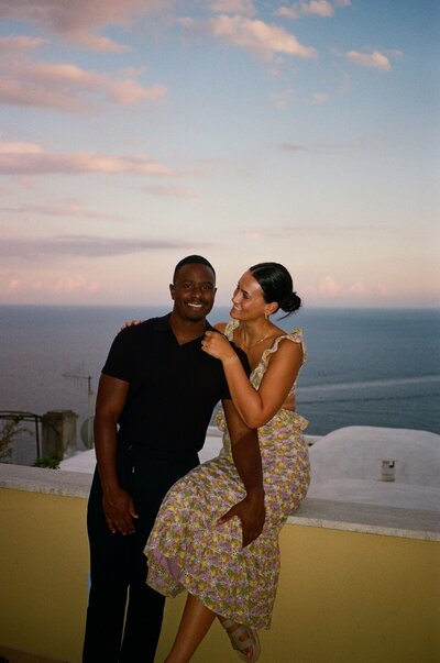 Georgia and Micah smiling at sunset in Positano, Italy.