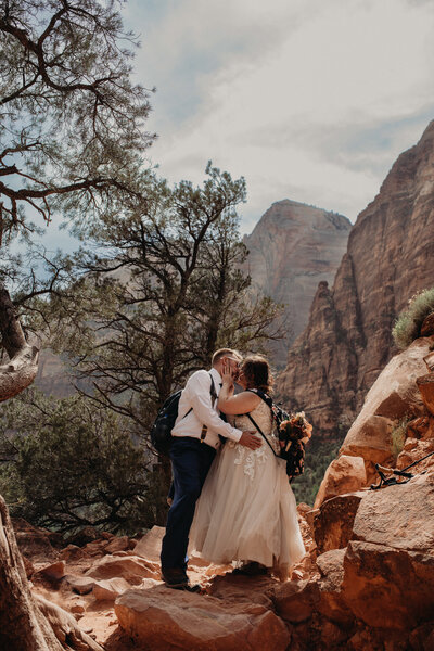 Newlywed couple kiss on top of mountain in Zion National Park, Utah by Paige Mireles a Cleveland photography