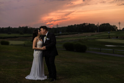 Couple kissing at sunset on the grounds of Lake View Country Club golf course