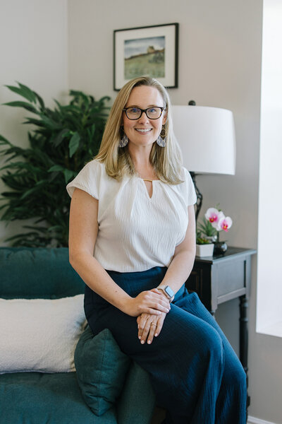 Kim Kussman, Utah Realtor & Owner of Nurture Lane, sitting at a realty listing