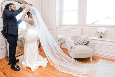 Beautiful bride admiring her wedding veil before the ceremony in a luxury bridal suite.