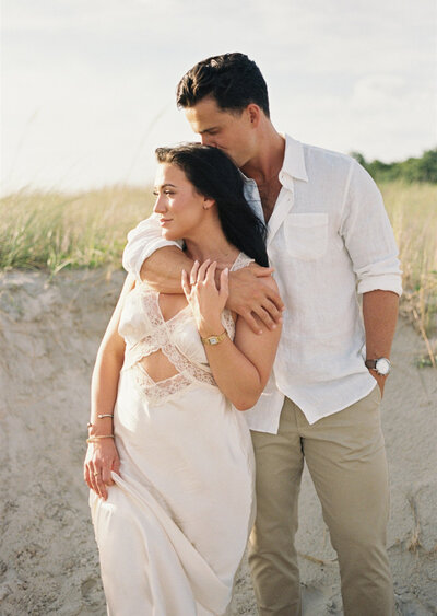 couple poses for their engagement photos on the beach