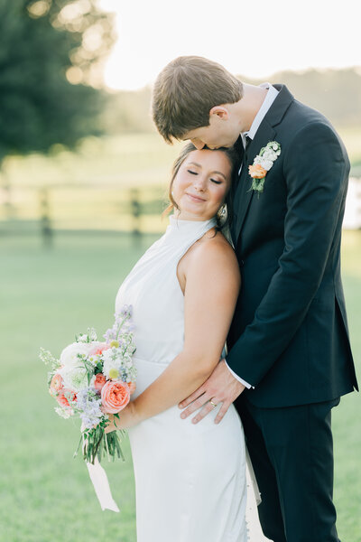 groom kissing bride on the head