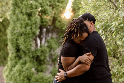 Couple embracing with the sunset behind them.