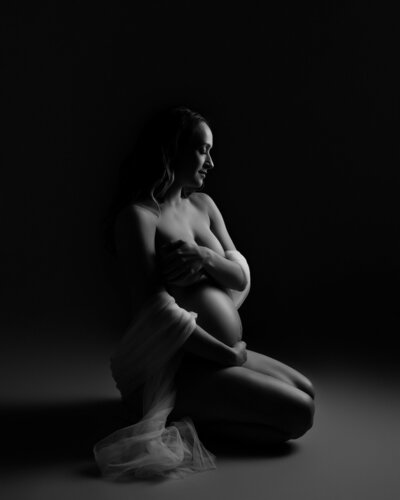 black and white photo pregnant woman with white fabric