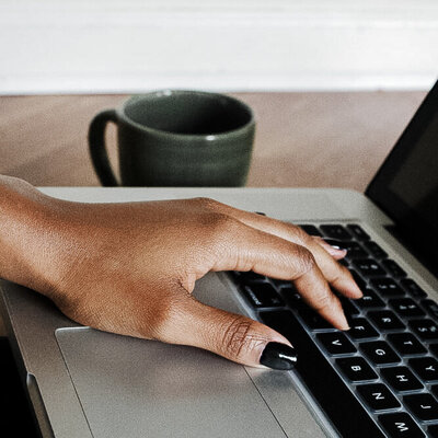 black-woman-hand-on-laptop-createherstock-e1556633220771