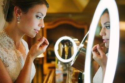 Bride putting on makeup before Ceremony