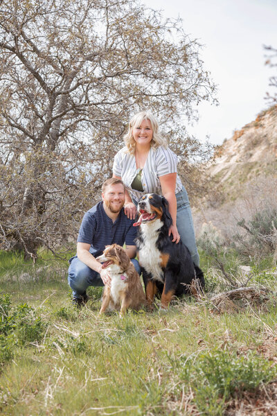 blonde woman and redhaired man with their two dogs  at a mountain park