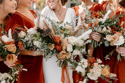 bride and bridesmaids holding flower bouquets