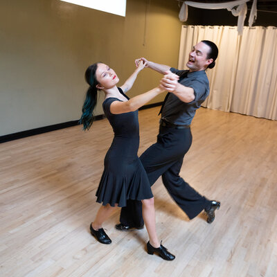 Couple taking a ballroom dance lesson.