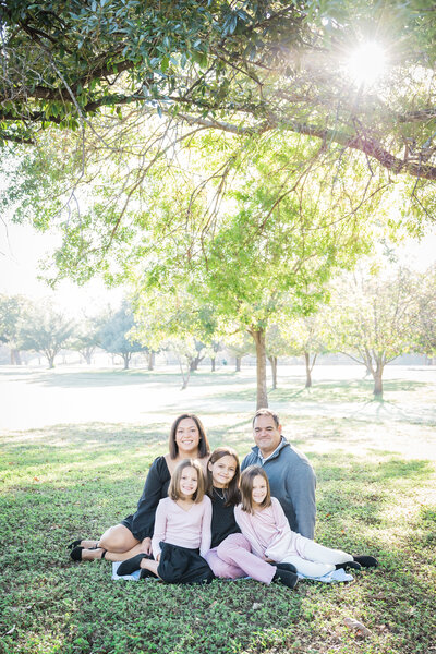 family posing under trees