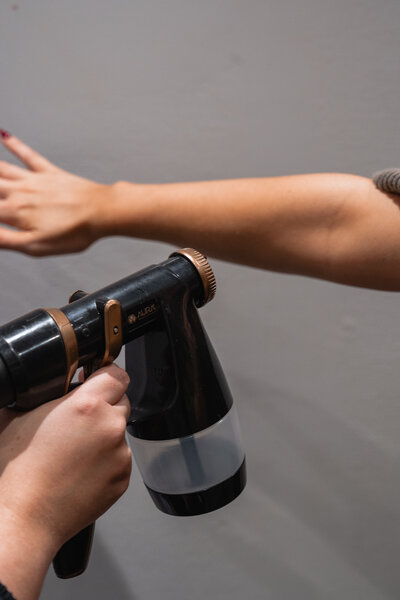 photo of woman receiving spray tan on her arm at dublins best spray tan salon