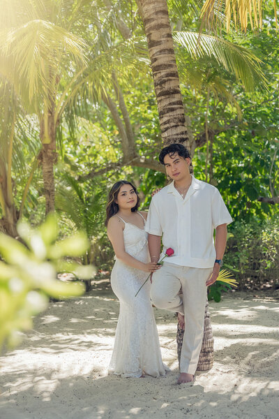 Sean and Graciela kissing under a white building