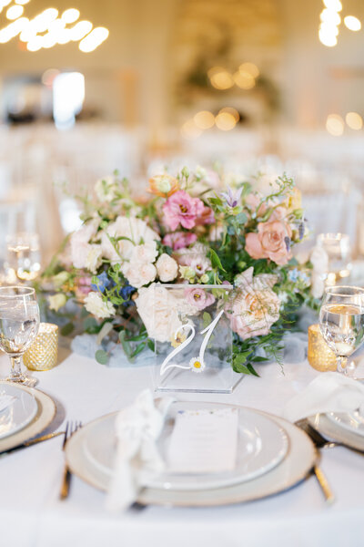 Reception table setting with colorful floral centerpiece