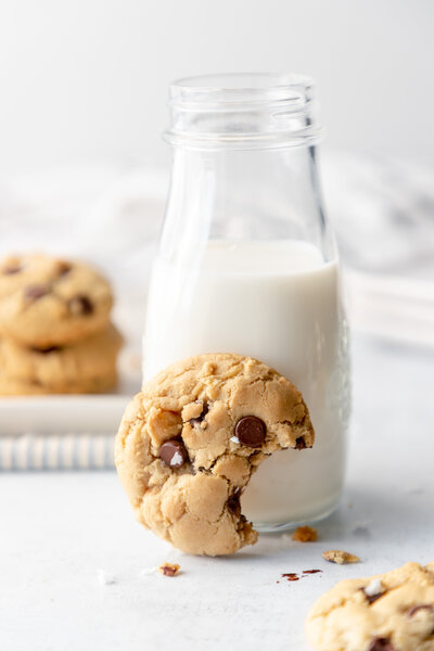 a chocolate chip cookie beside a glass of milk