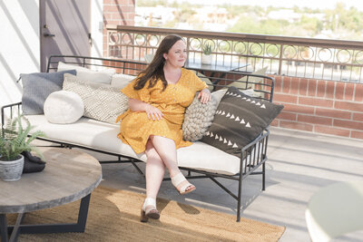 a woman sitting on a sofa looking off into the distance