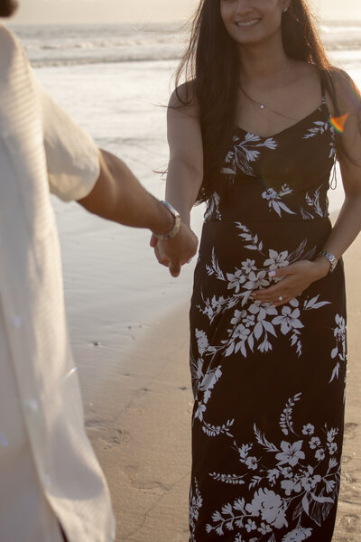 Close-up of a pregnant woman holding a baby’s breath bouquet with a framed ultrasound resting on her lap