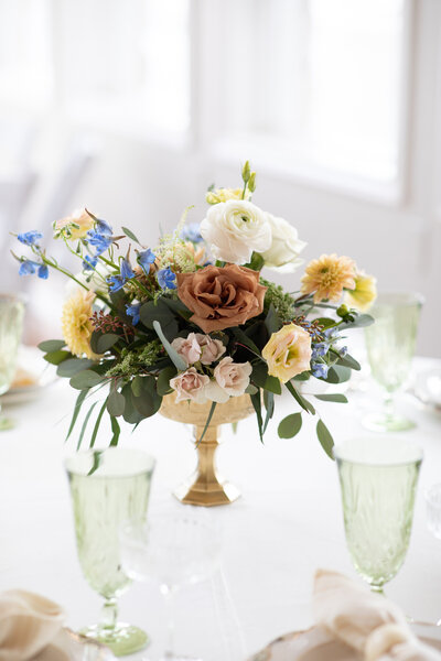 Austin-based wedding photographer captures a stunning table setting featuring exquisite flowers in a gold vase.