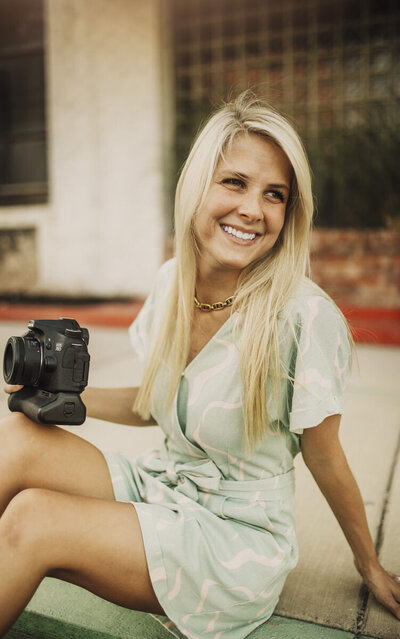 woman smiling holding camera