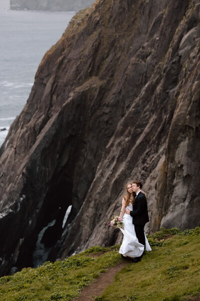 Couple embracing near the edge of a cliff on the Oregon Coast.
