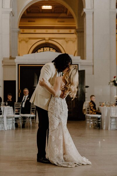 A newlywed couple kissing during their first dance 