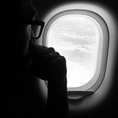Leo Payne, a destination wedding videographer looking outside from a plane