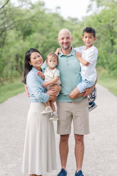 parents posing for a photo with their two young boys