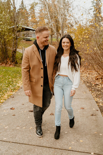couple walking in fall leaves