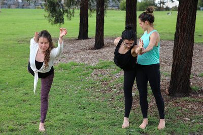 Ariane assisting a client in a yoga pose