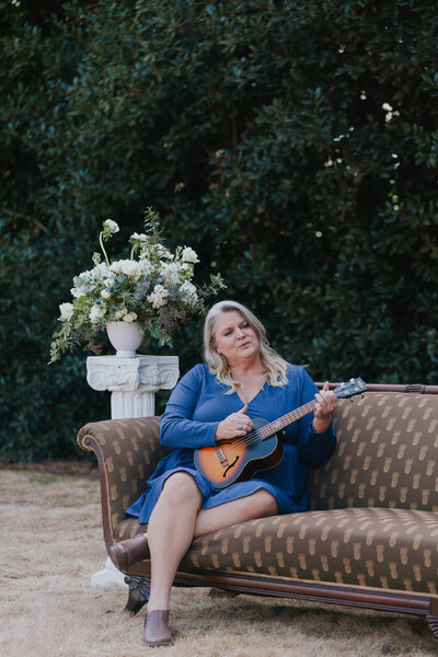 singer-songwriter-playing-ukulele-seated-on-anitique-couch-for-brand-session-belle-crane-inn