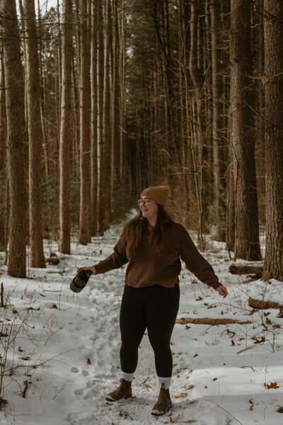 photo of woman standing in the forest