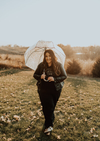 Nicole, holistic hair stylist and owner of Haven Beauty Collective, standing outdoors with umbrella, reflecting calm, authenticity, and natural beauty.