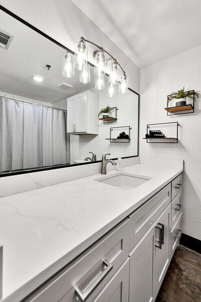 Beautiful white bathroom in this one-bedroom, one-bathroom luxury condo in the historic Behrens building in downtown Waco, TX.