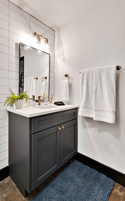 Bathroom vanity and plush towels in this one-bedroom, one-bathroom luxury rental condo in the historic Behrens building in downtown Waco within walking distance to the Silos, Baylor, and local museums.