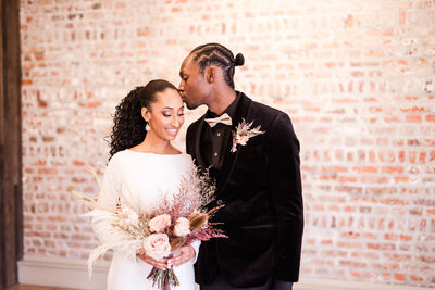 black groom kissing bride on wedding day