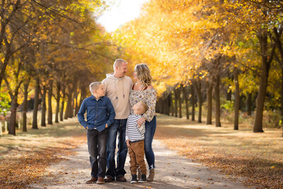 Beautiful golden trees frame this family for their outdoor fall session in Minnesota.