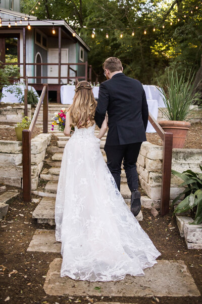 Bride and groom walking up an outdoor stairs