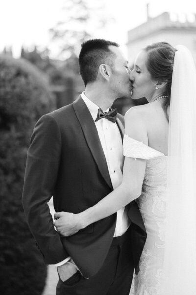 Bride and groom kissing during their wedding day, timeless black and white portrait by a Toronto-based wedding photographer