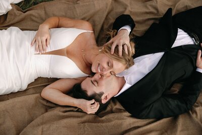 Bride and groom cuddle on picnic blanket during Colorado elopement.
