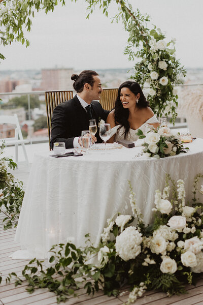 Bride and Groom laugh at their table surrounded by floral at Highpoint at 1333 New Hampshire in Washington DC