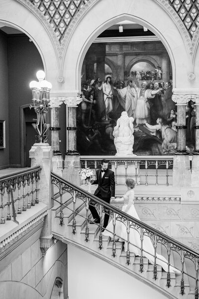 Bride and groom walks up the stairs at the Pennsylvania Academy of the Fine Arts in Philadelphia