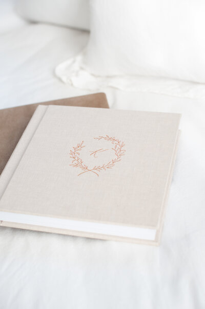 detail shot of an heirloom album. The album has a cream, linen cover with a gold K embossed on the front cover.