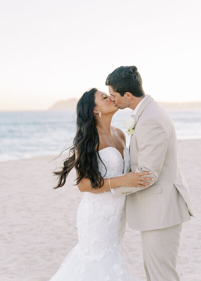 bride and groom kissing on the beach