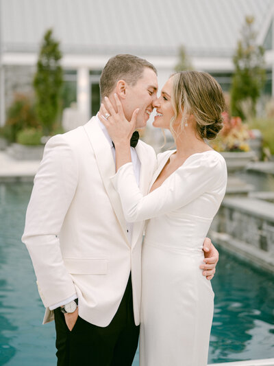 Just married couple embracing in front of a pool photographed by Charlottesville Virginia Wedding Photographer Amanda Adams