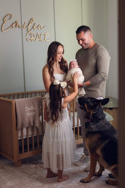 A tender moment of a family with their newborn and dog, beautifully photographed by Bia Schaefer photography in Orlando, Florida.