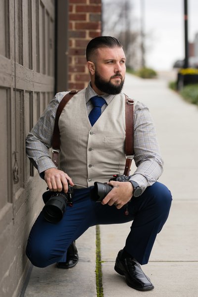 Zack Hawkins, male photographer, owner of Hawkins Film Co, posing for portraits with sony and holdfast moneymaker gear downtown Knoxville on Jackson Avenue in front of the Standard Wedding venue