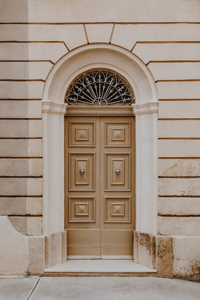 Elegant old-world doorway with architectural transom, exuding classic European style. Tailored Oasis Travel Co.