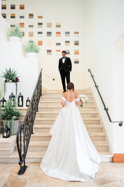 Groom turning around to see his bride walking up the stairs at the Four Seasons wedding venue in Scottsdale