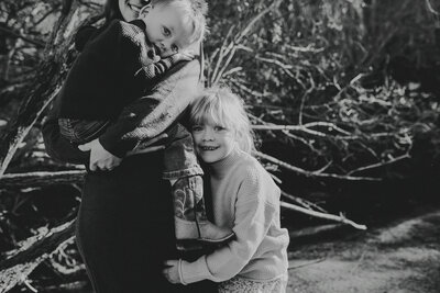 black and white photograph of a dad pushing a laughing child on a tire swing by Spearfish, South Dakota photographer Rooted and Wild Photography